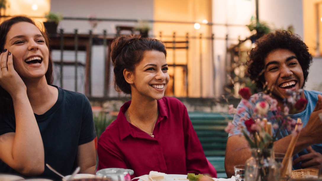 A woman enjoying dinner with a group of friends