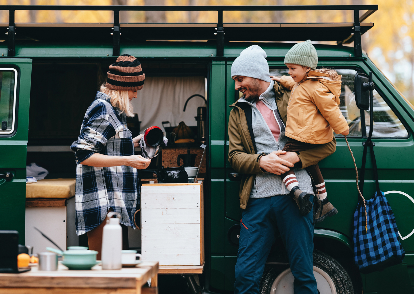 A family prepping for an outdoor adventure outside their van